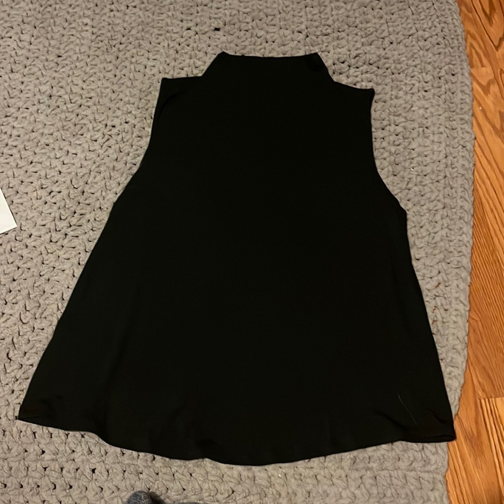 Black mock neck sleeveless top.
